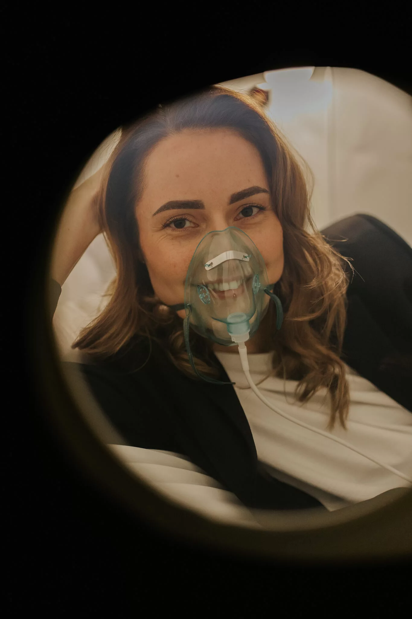 Zrelaksowana klientka podczas bezbolesnego zabiegu tlenoterapii hiperbarycznej w Si Longevity Center w Szczecinie.